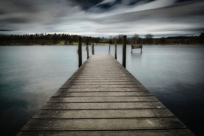 Pier over lake against sky