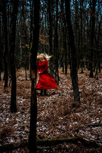 Man standing on field against trees in forest