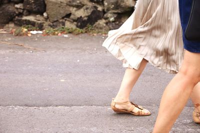 Low section of women walking on street