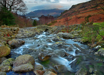 Scenic view of river amidst mountains against sky