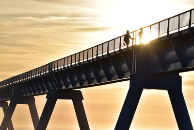 Low angle view of bridge against sky during sunset