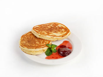 Close-up of breakfast served in plate against white background