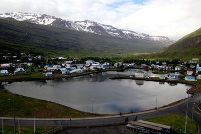 Scenic view of lake by mountains against sky