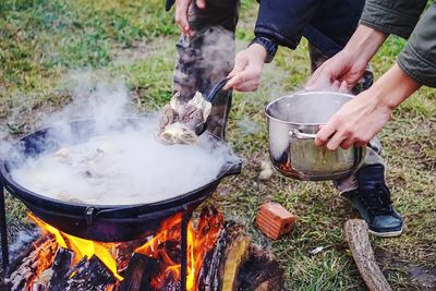 People preparing food on bonfire