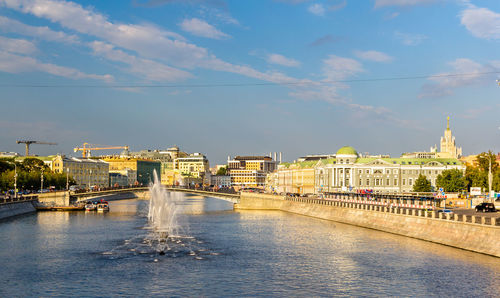 River amidst buildings in city against sky