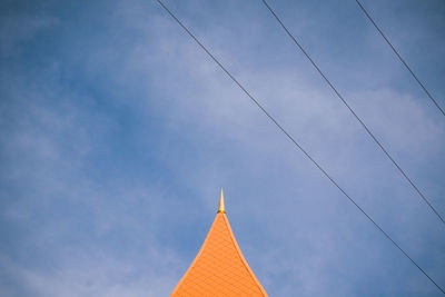 Low angle view of cross on building against sky