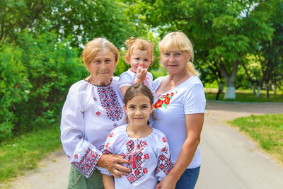 Happy family standing against tree outdoors