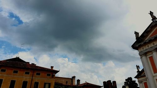 Low angle view of building against cloudy sky