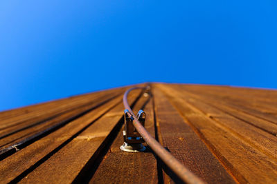 Low angle view of metal against blue sky