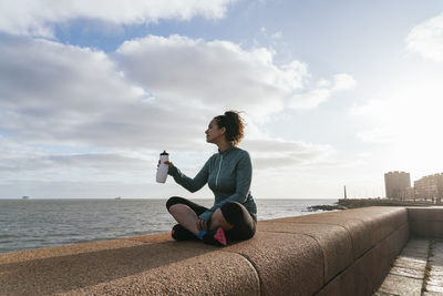 Runner woman drinking water outdoors