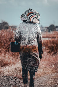 Rear view of woman standing on field