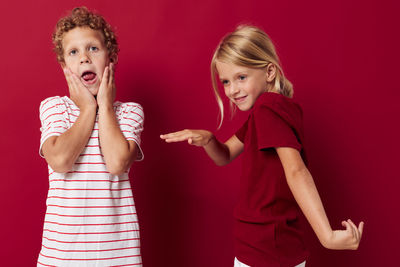 Sibling dancing against red background