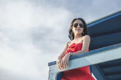 Young woman wearing sunglasses against sky