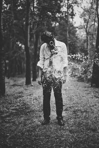 Full length of woman photographing in forest