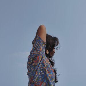 Rear view of woman standing against sky