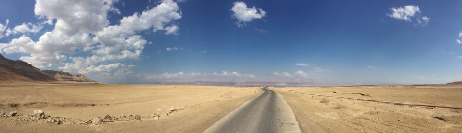 Panoramic view of desert road against sky