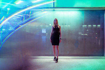 Portrait of woman standing on floor against window