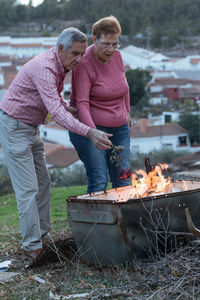 Senior couple burning rose standing outdoors