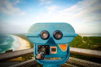 Close-up of coin-operated binoculars against sea