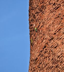 Low angle view of wall against clear blue sky