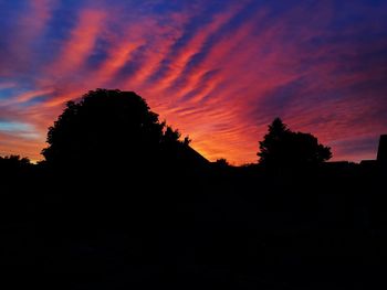 Silhouette trees against sky at sunset