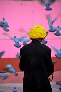 Rear view of man and woman standing against pink background