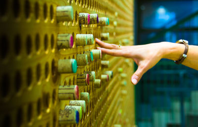 Cropped image of woman with wine bottles on rack