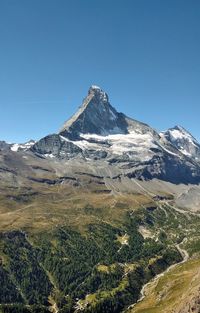 Scenic view of snowcapped mountains against clear blue sky