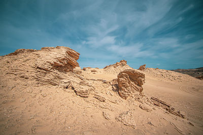 Rock formation on beach against sky