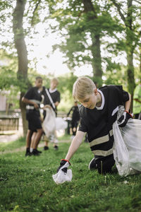 Blond boy collecting plastic in garbage bag