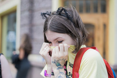 Close-up of woman covering face with t-shirt