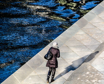 High angle view of woman walking on promenade during sunny day