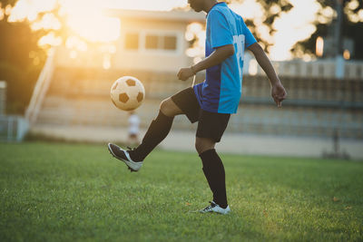 Man playing soccer ball on grass