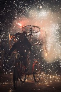 Bicycles parked in city at night fireworks at dimonis festival in majorca spain