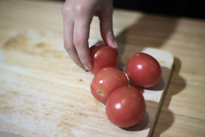 Close-up of hand holding berries on table