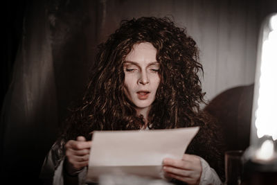 Portrait of a beautiful young woman holding paper