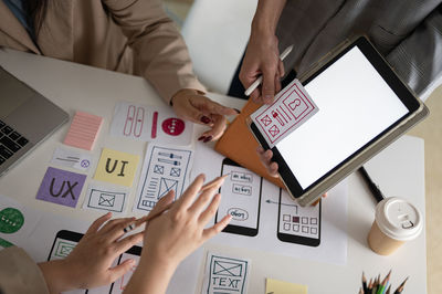 Midsection of business people working on table