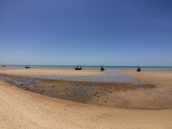 Scenic view of beach against clear blue sky