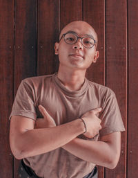 Portrait of young man standing against wall