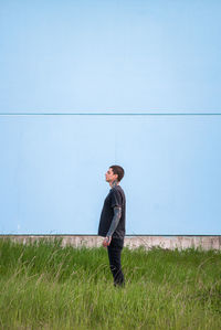 Side view of young man standing on field