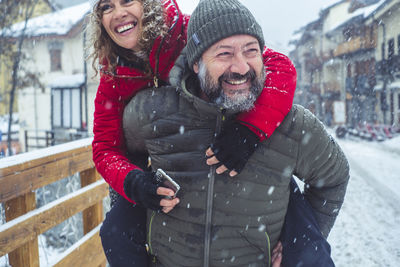 Portrait of smiling young woman standing in snow