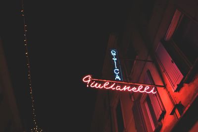 Low angle view of illuminated sign at night