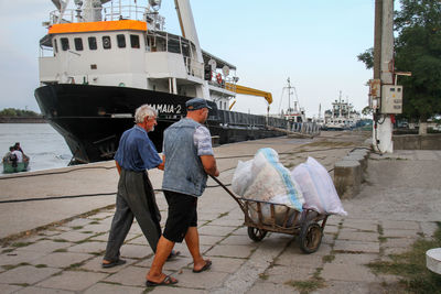 Men standing on boat against sky