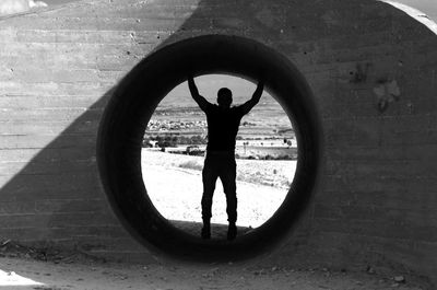 Silhouette man standing by window