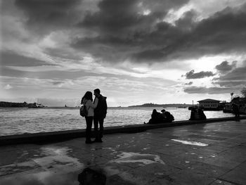 People standing on beach against sky