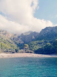 Scenic view of sea and mountains against sky