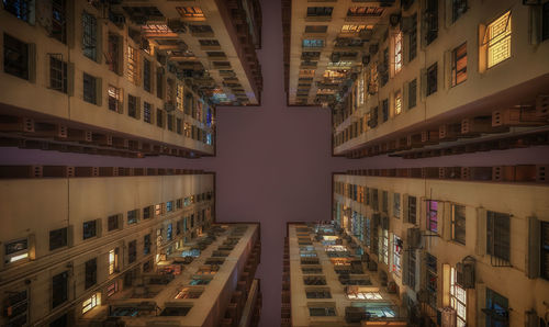 Directly below shot of buildings against sky in city