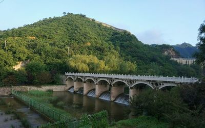 Arch bridge over river against sky