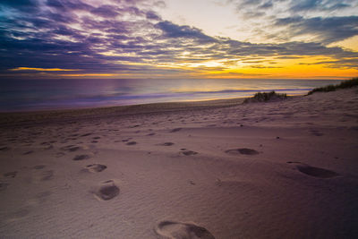 Scenic view of beach against cloudy sky