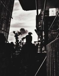 Rear view of people sitting on road against sky